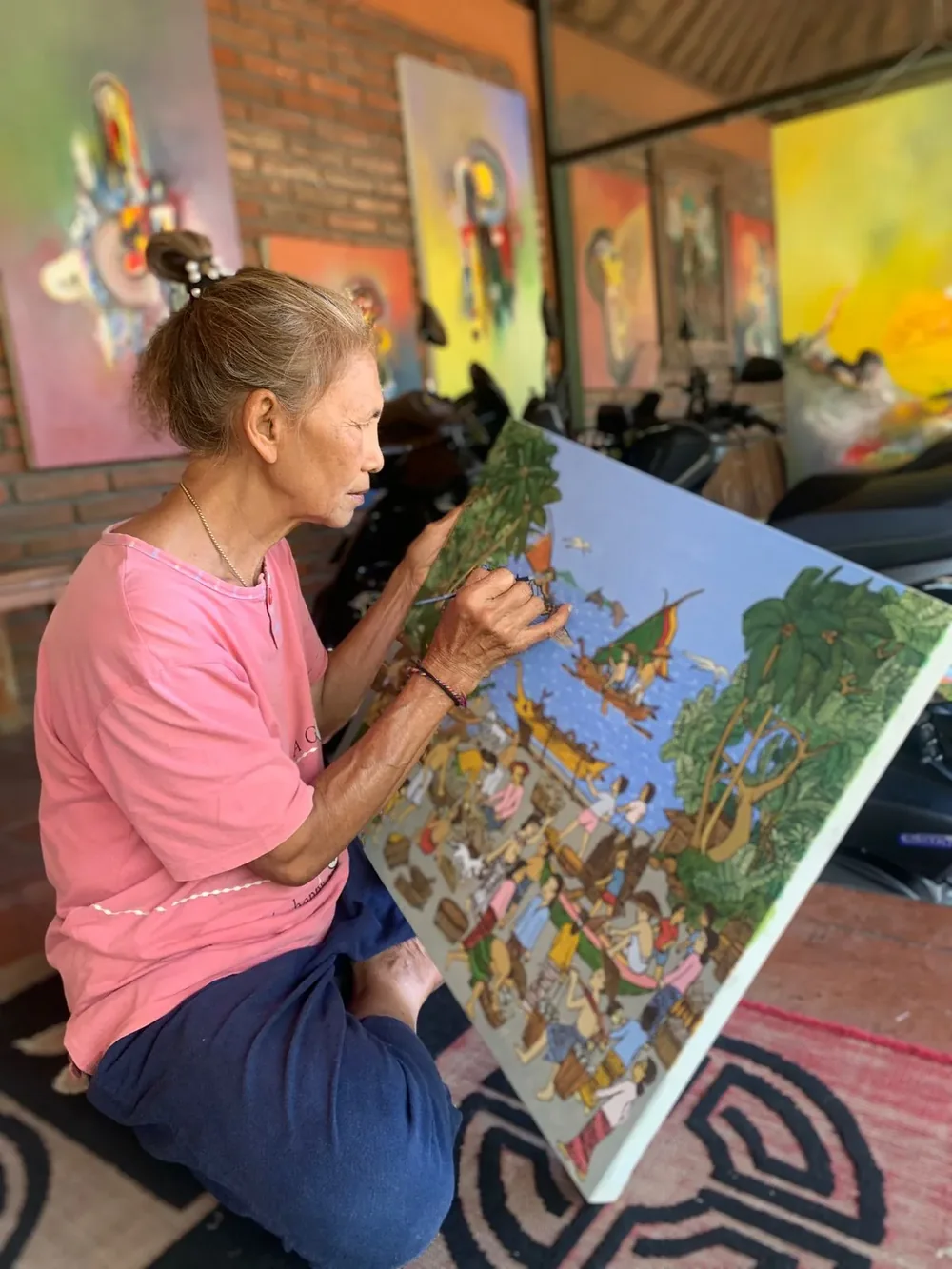 Jero Wayan Amer Ambarie painting on the floor of her studio