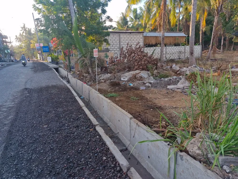 The main road frontage of the plot for lease on Nusa Penida, with a new concrete drain along the verge
